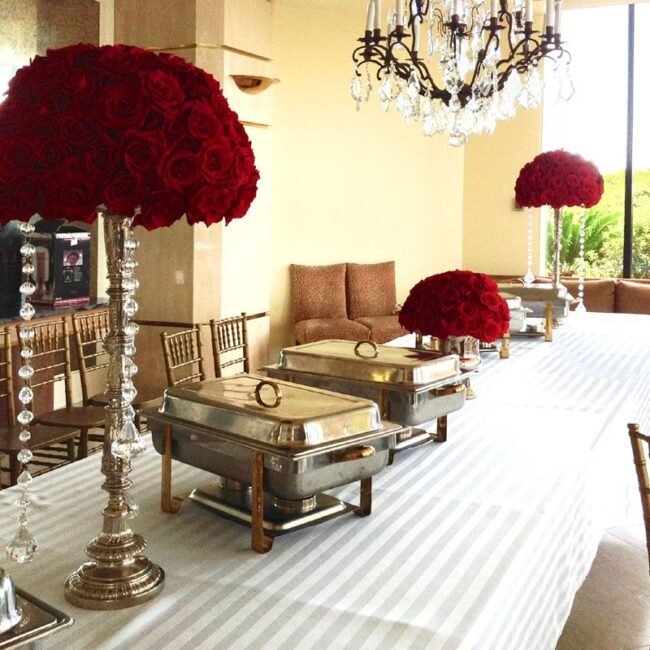 Large rose centerpieces decorating tables at a beautifully catered event, adding elegance and sophistication.