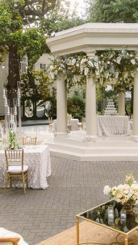 Romantic courtyard set for a wedding, featuring elegant seating, floral décor, and a picturesque backdrop ready to welcome guests for the ceremony.