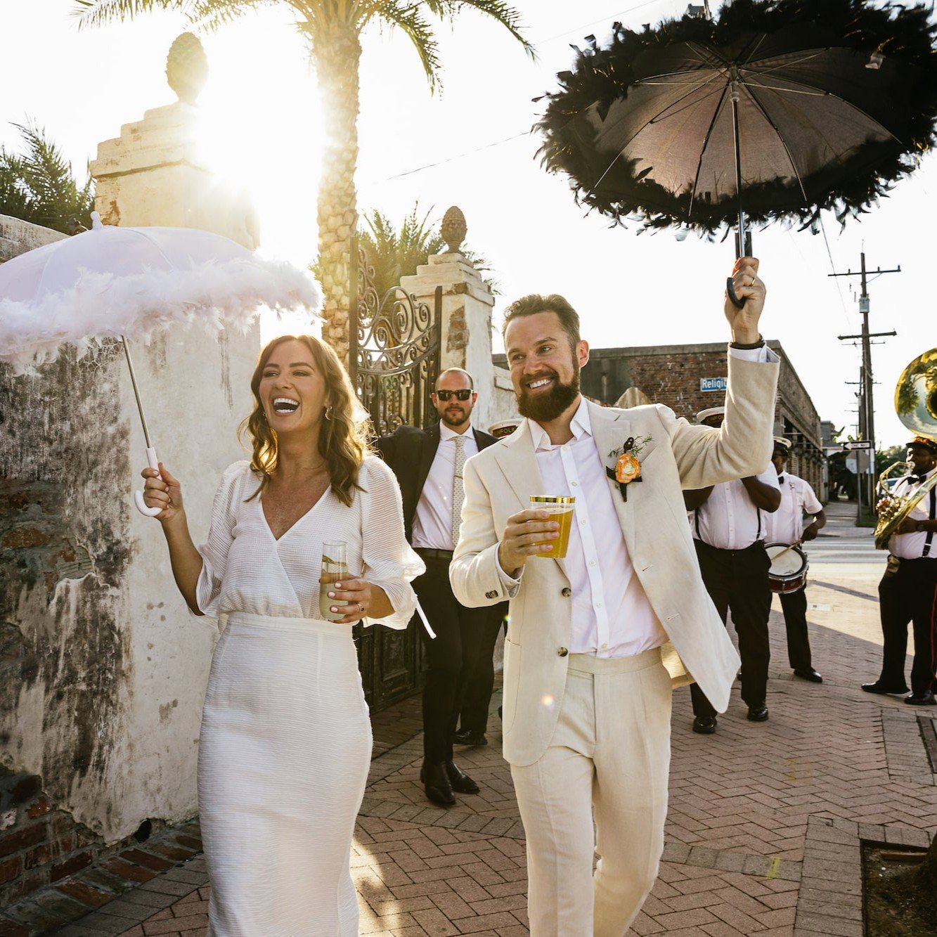 Just-married couple second lining through the streets of New Orleans, celebrating with a joyful and lively traditional parade.