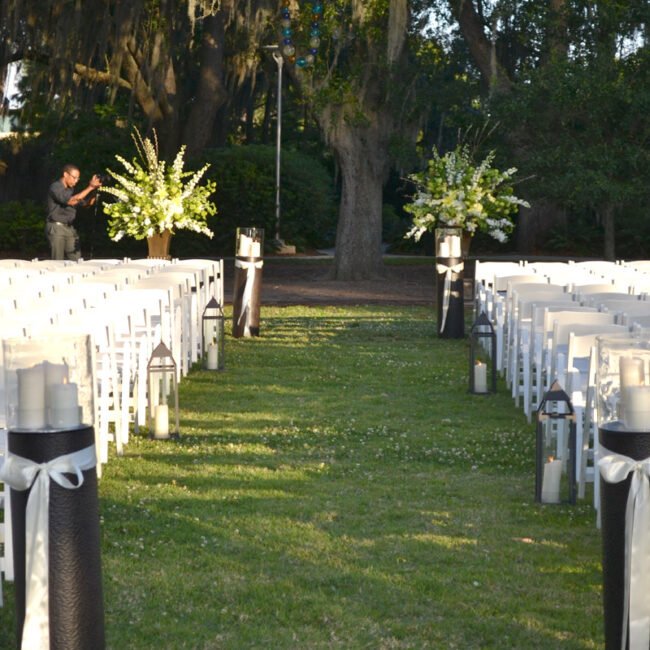 Large white floral arrangements displayed for an outdoor ceremony, creating a timeless and sophisticated setting.
