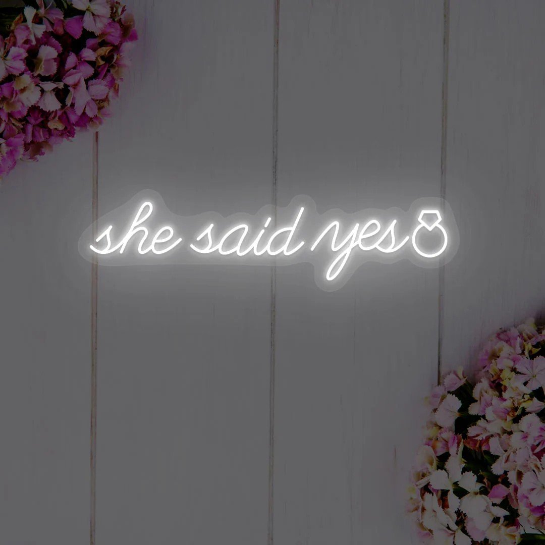 Neon sign that says "she said yes"
