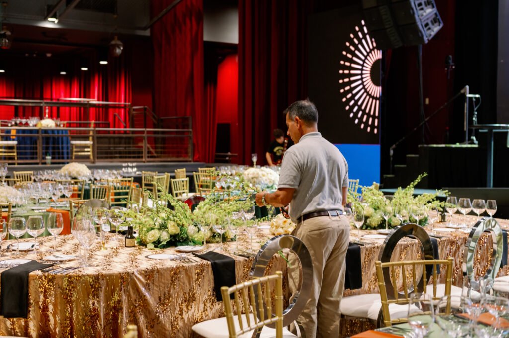 A team member preparing reception tables and floral centerpieces at The Fillmore.