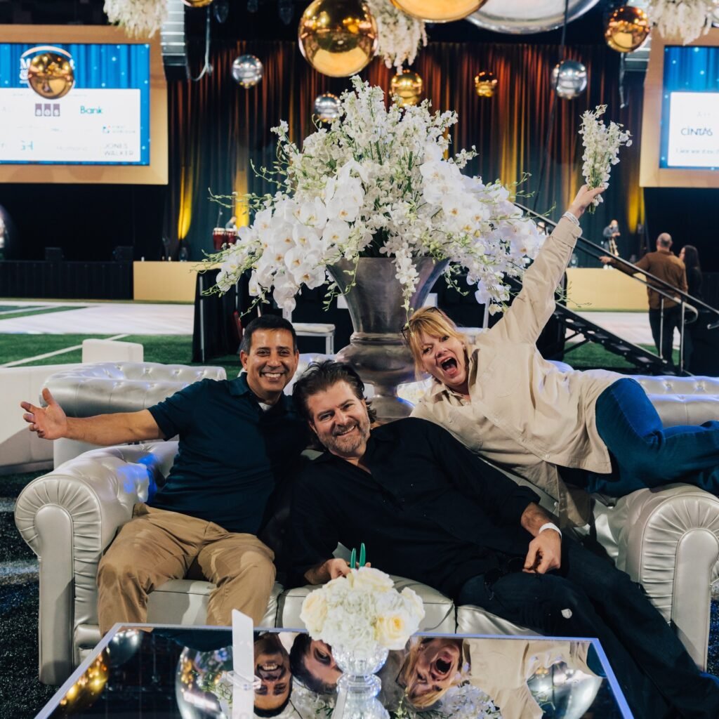 The Perfect Presentations team together beside a white floral installation at the Moonlight Gala.