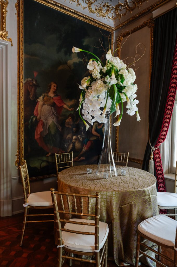 Tall white floral centerpiece beside a painted wall at the Brown-Villere Mansion.